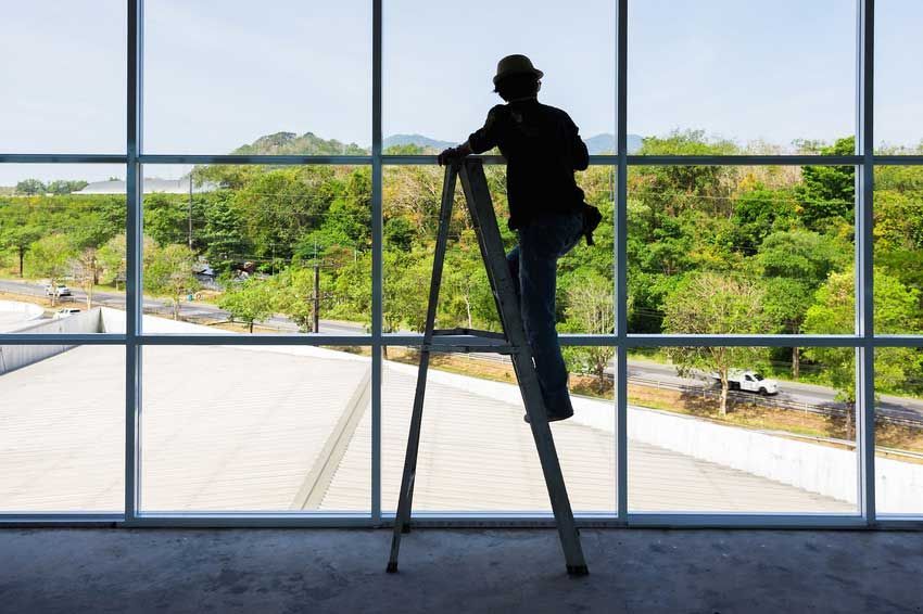 Technician on a ladder at a residential window